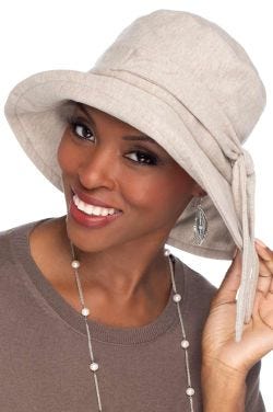 Woman in oatmeal big brimmed cotton UPF hat with adjustable tie for cancer patients