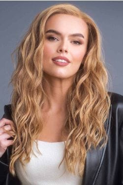 Woman in an extra long warm blonde curly lace front wig