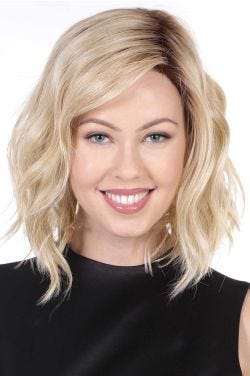 Woman in a shoulder length light blonde wavy lace front wig