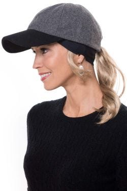 Woman in headband with ponytail attached worn under a baseball cap