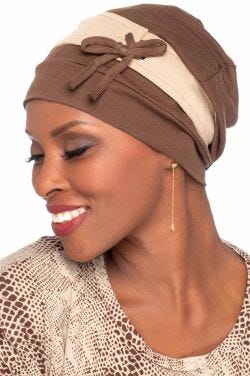 Woman in a slouchy snood style burgundy chemo turban with laces and bow on the side
