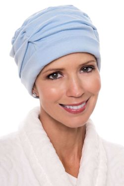 Woman in light blue shirred cotton sleeping cap for cancer patients