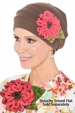 Woman in a taupe Slouchy Snood Hat with a pink aster flower pin attached