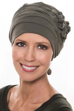 Woman in olive bamboo flapper style chemo hat with large ruched side flower