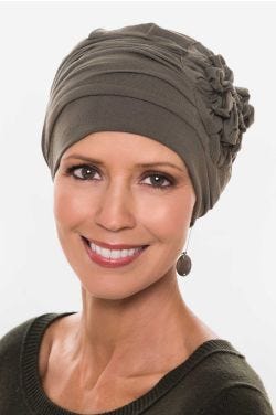 Woman in olive bamboo flapper style chemo hat with large ruched side flower