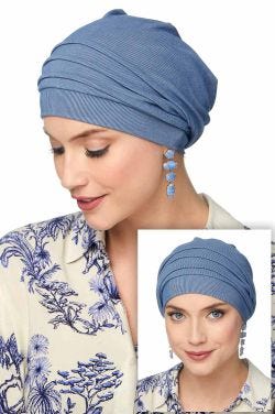 Woman in beanie style blue cancer head covering with draping in back