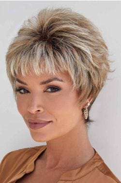 Woman in a blonde pixie wig with longer layering on top and short fringe bangs
