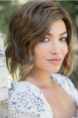 Woman in a shoulder length choppy light brown wavy lace front wig