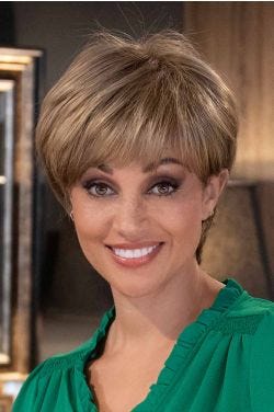 Woman in a long dark auburn feathered pixie wig with fringe bangs and longer hair at the nape