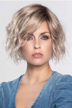 Woman in a chin length curly platinum blonde lace front wig