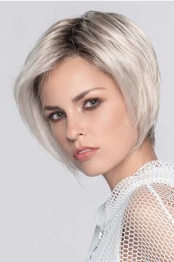 Woman in a chin length platinum blonde angled bob wig