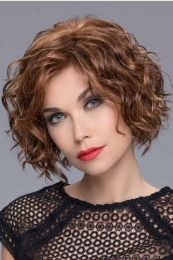 Woman in a chin length medium auburn curly lace front wig