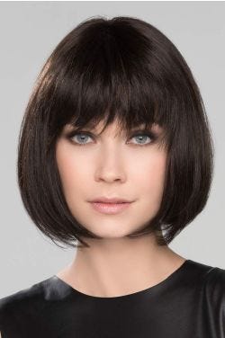 Woman in a chin length dark brown bob wig with choppy bangs