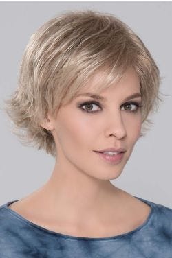Woman in a light blonde pixie wig with longer hair on top and side bangs