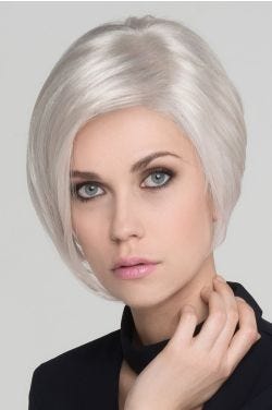 Woman in a chin length asymmetrical platinum blonde angled bob wig