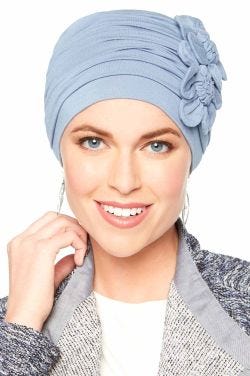 Woman in blue bamboo flapper style cancer hat with two rosette flowers on the side