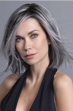 Woman in a shoulder length dark to medium grey blunt bob wig with long bangs