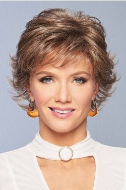 Woman in a flipped out brown grey short wig with wispy bangs