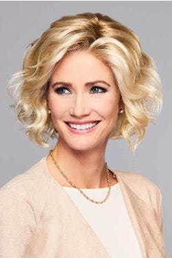 Woman in a large chin length light blonde curly lace front wig