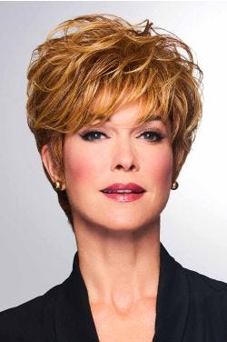 Woman in a medium brown pixie wig with side bangs and longer hair on the top