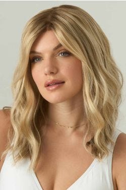 Woman in a just past the shoulders light ash brown wavy wig with long side-swept bangs and dark roots