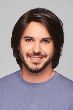 Man in a shoulder length dark brown human hair wig with shorter sides