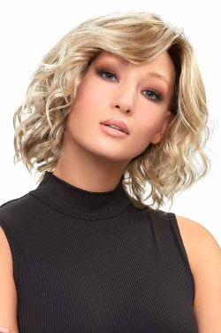Woman in a shoulder length light blonde curly lace front wig