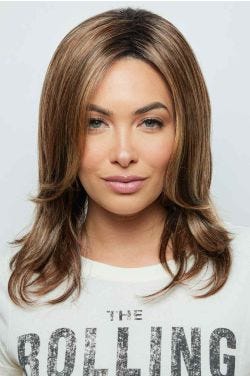 Woman in a past the shoulders light brown wig with long curtain bangs