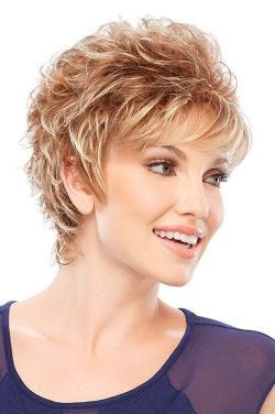 Woman in a curly auburn highlighted pixie wig with side swept bangs