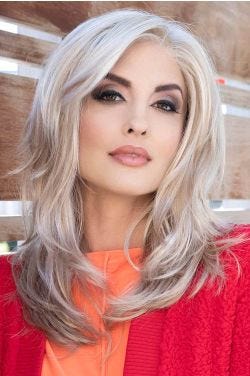 Woman in a past the shoulders light blonde wavy lace front wig with layers and side bangs