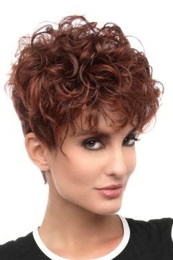 Woman in a dark red curly pixie wig with long layers on top