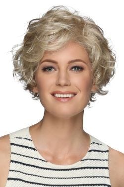 Woman in a long curly dark blonde layered pixie wig