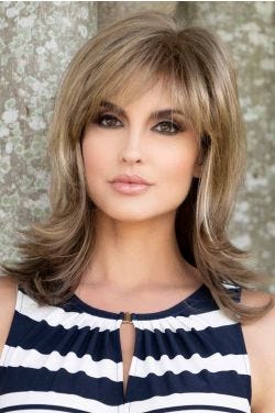 Woman in a shoulder length blonde wig with long feathered layers and bangs