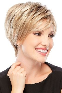 Woman in a petite asymmetric short blonde bob wig with side swept bangs and longer layers at the back