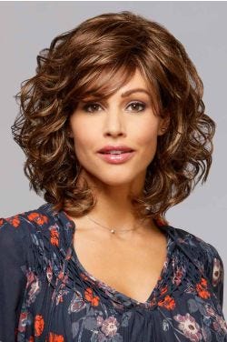 Woman in a medium brown curly wig with ample volume and side swept bangs