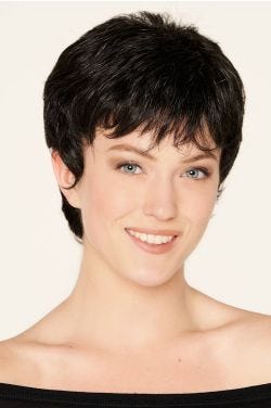 Woman in a large close cropped dark brown pixie wig with wispy bangs