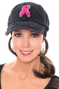 Woman in black baseball cap with pink breast cancer ribbon on the front