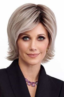 Woman in a shoulder length razor cut light blonde wig with fringe bangs