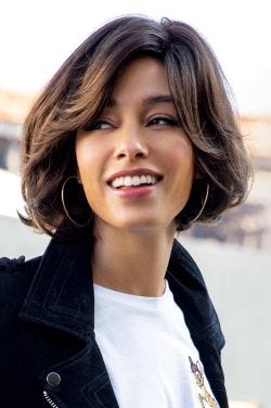 Woman in a chin length brown bob wig with long layers around the face