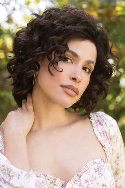 Woman in a shoulder length curly dark brown lace front layered wig