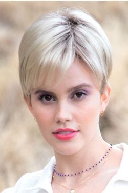 Woman in a light blonde pixie wig with bangs and longer layers on top