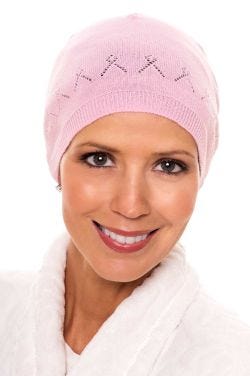 Woman in pink beanie style sleeping cap with breast cancer ribbons knitted into the design