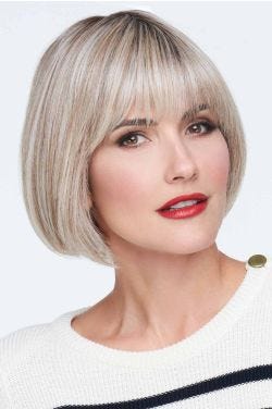 Woman in a past the chin ash blonde stacked lace front bob wig with fringe bangs