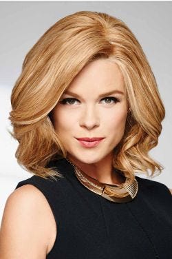 Woman in a light auburn, curly, shoulder length bob wig