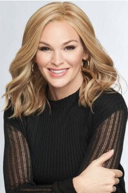 Woman in a past the shoulders curly warm blonde lace front wig