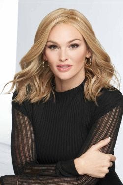 Woman in a past the shoulders curly warm blonde lace front wig