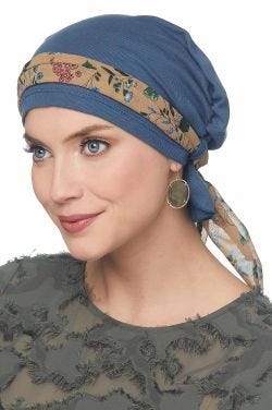 Woman in blue chemo beanie with scarf looped through the head covering