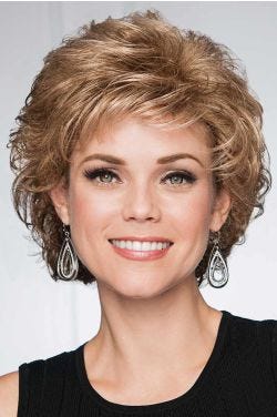 Woman in a short light brown bob wig with curled layers and fringe bangs