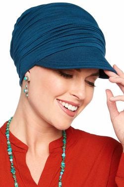 Woman in blue newsboy hat for women with cancer with relaxed pleats in back