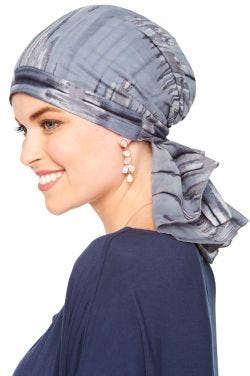 Woman in blue tie dye pre tied head scarf for women with cancer